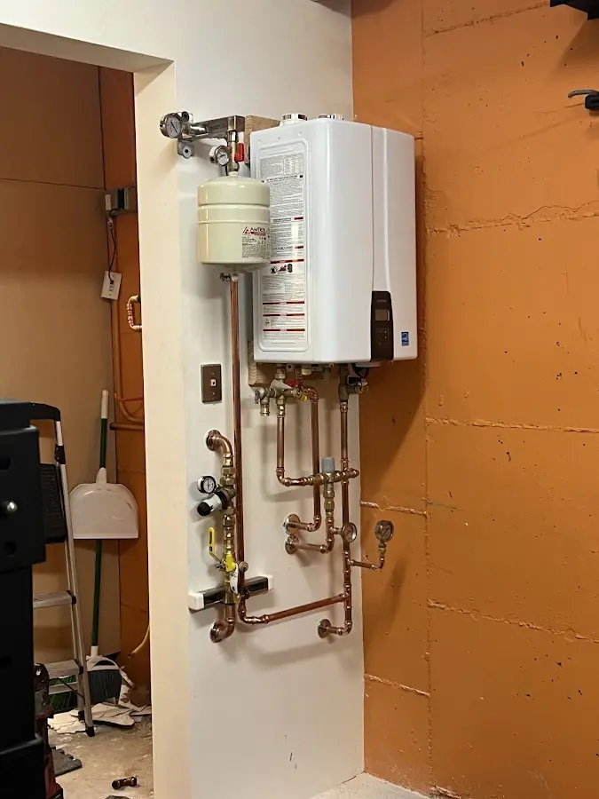 Plumbing technician inspecting water heater connections in Townsend